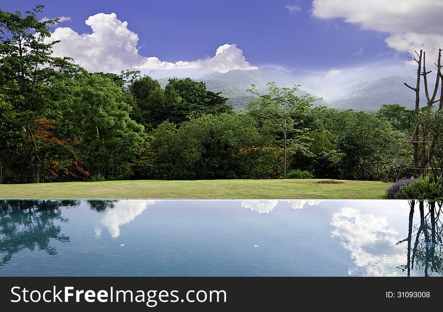 Cloud reflections on the infinity pool with beautiful landscape background