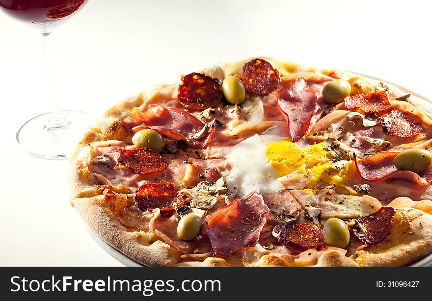 Pizza with eggs, ham and sausages.