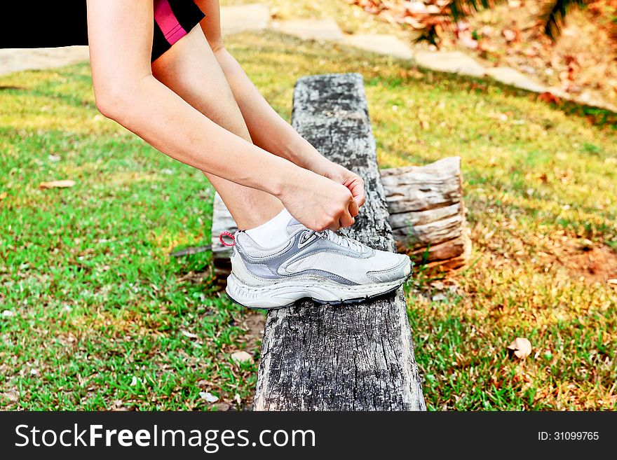 Young woman tying her shoe. Young woman tying her shoe