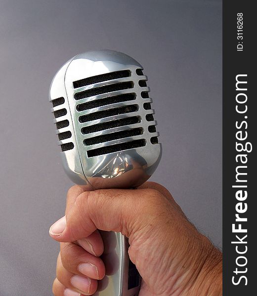 A hand-held retro vintage fifties microphone.