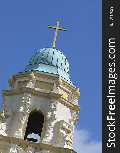 Top of a church tower with a cross on blue sky. Top of a church tower with a cross on blue sky.