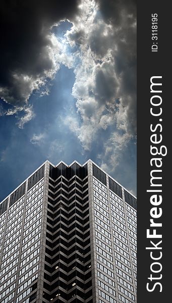 Office building with dramatic cloudy skies and lighting. Office building with dramatic cloudy skies and lighting.