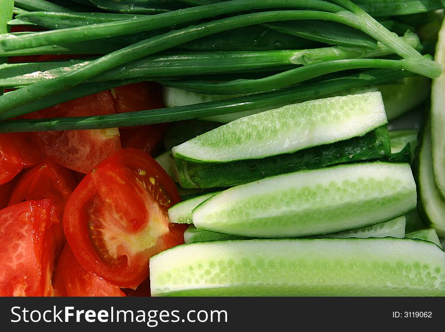 Allsorts from vegetables - ripe tomatoes, cucumbers, a green onions