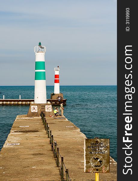 Vertical image of green and red lighthouses at end of piers on lake. Vertical image of green and red lighthouses at end of piers on lake
