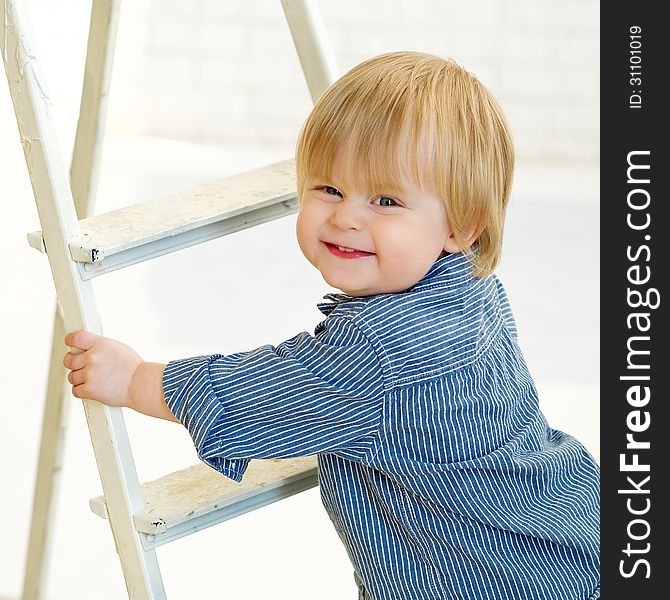 Happy little boy climbing the ladder