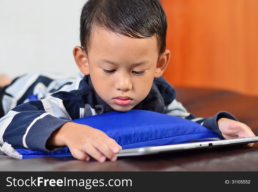 Close up a boy playing a game on computer tablet