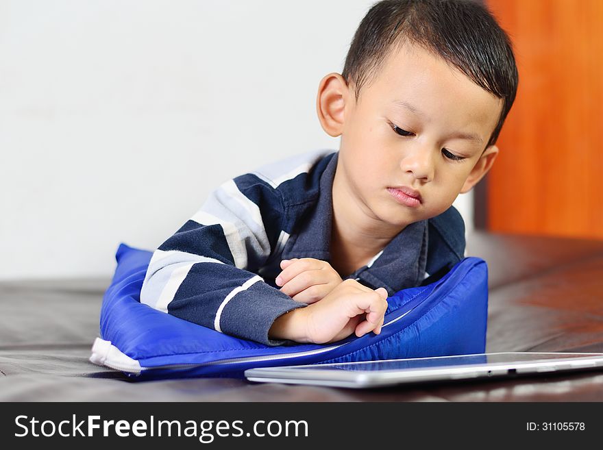 A boy playing a game on computer tablet