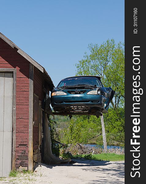 Old Ford Mustang Hanging From Garage