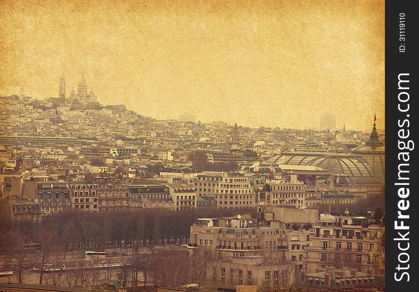 The view on the old part of Paris, the faraway Montmartre. Photo in retro style. Paper texture.