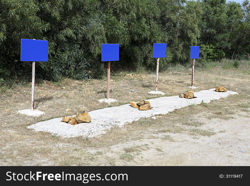 Four blue signs indicate danger with stones placed side.