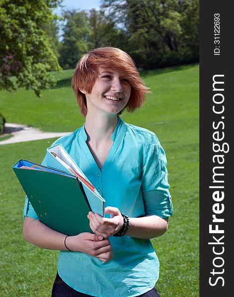 Happy Young Woman Holding A File Folder Outdoors