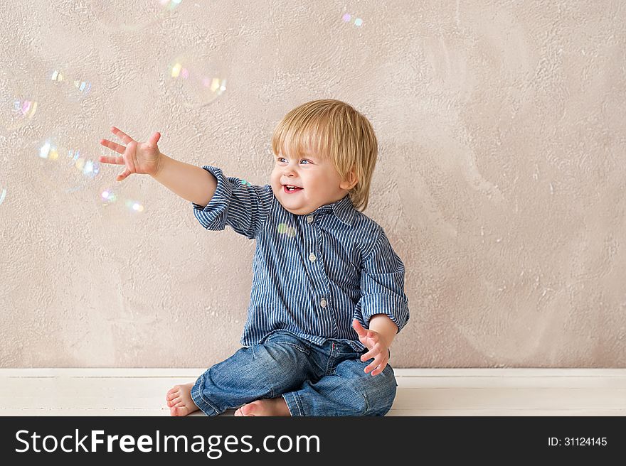 Laughing kid playing with soap bubbles. Laughing kid playing with soap bubbles