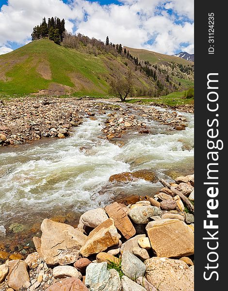 View to the foothills of the Caucasus mountains over stream near Arkhyz, Karachay-Cherkessia, Russia. View to the foothills of the Caucasus mountains over stream near Arkhyz, Karachay-Cherkessia, Russia