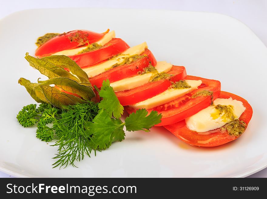 Greek classic summer salad of red big juicy tomatoes cutting circles to 2 millimeters, fresh and soft goat cheese feta sauce of special herbs, served with parsley, dill and fezalis. Greek classic summer salad of red big juicy tomatoes cutting circles to 2 millimeters, fresh and soft goat cheese feta sauce of special herbs, served with parsley, dill and fezalis