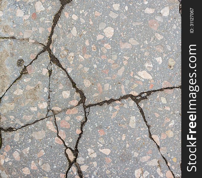 A large number of deep cracks and small scratches in surface of the concrete with granite interspersed. A large number of deep cracks and small scratches in surface of the concrete with granite interspersed