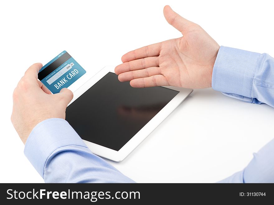 Man's hand holding a credit card over a tablet computer and the other hand directing toward the screen on a white background. Man's hand holding a credit card over a tablet computer and the other hand directing toward the screen on a white background.