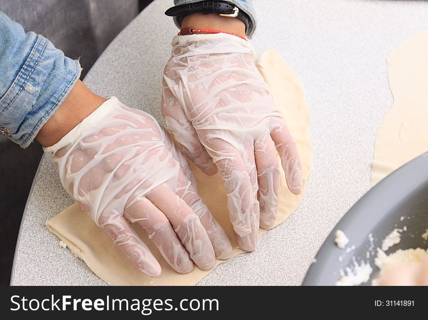 Pie crust made from flour and water to clean hands covered with plastic gloves