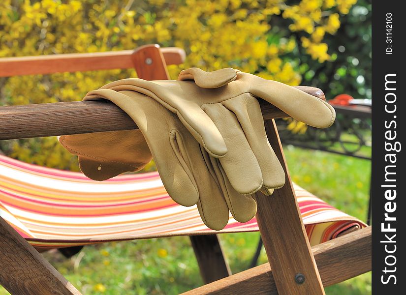 Gardening gloves resting on the arm of a chair