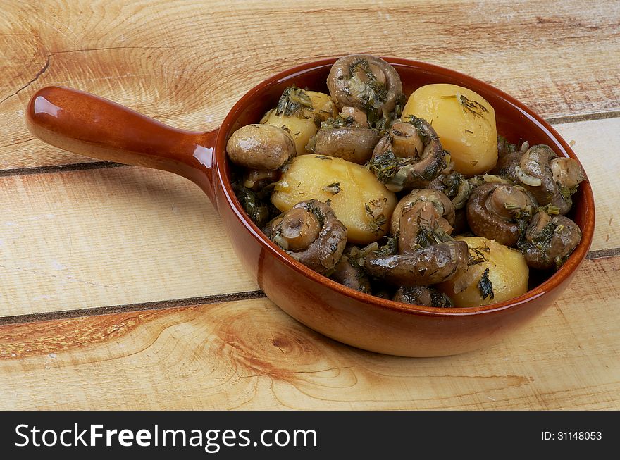 Delicious Stew with Champignon Mushrooms, Roasted Potato, Greens and Onion in Brown Frying Pan closeup on Wood background. Delicious Stew with Champignon Mushrooms, Roasted Potato, Greens and Onion in Brown Frying Pan closeup on Wood background