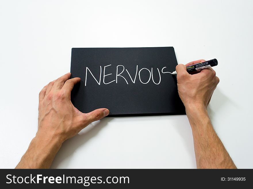 Two hand writing nervous in white on a black background