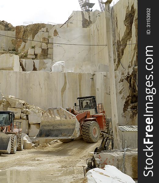 Excavators working for the transport of white marble, cut into blocks. Excavators working for the transport of white marble, cut into blocks