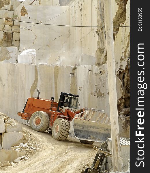 Excavators working for the transport of white marble, cut into blocks. Excavators working for the transport of white marble, cut into blocks