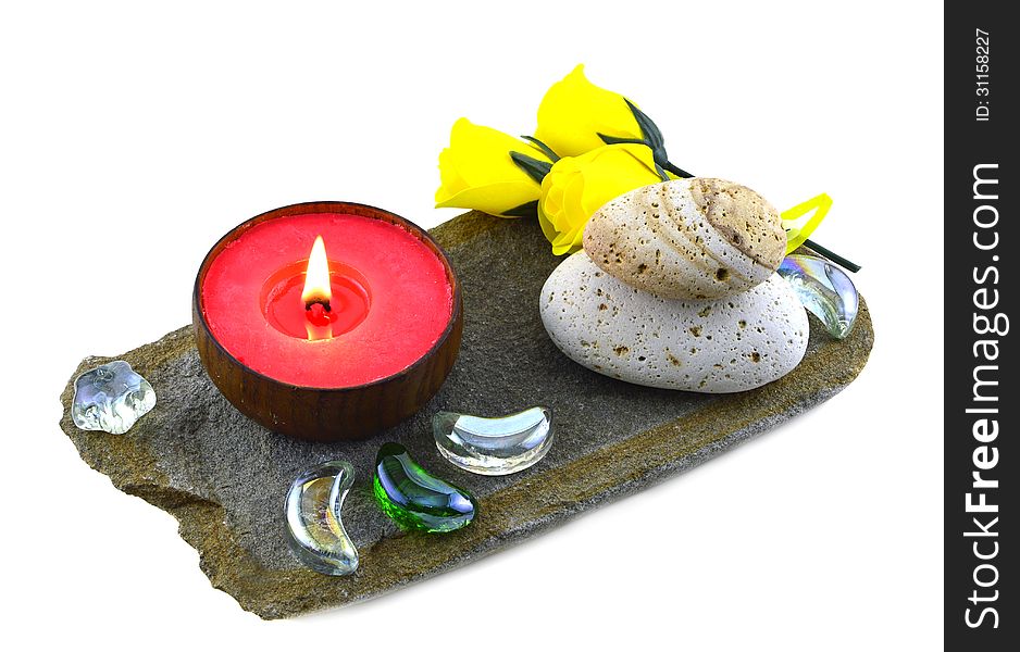 Red candle with yellow roses and stones isolated. Red candle with yellow roses and stones isolated