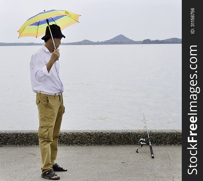 Senior Fisherman Waiting For Catches A Fish