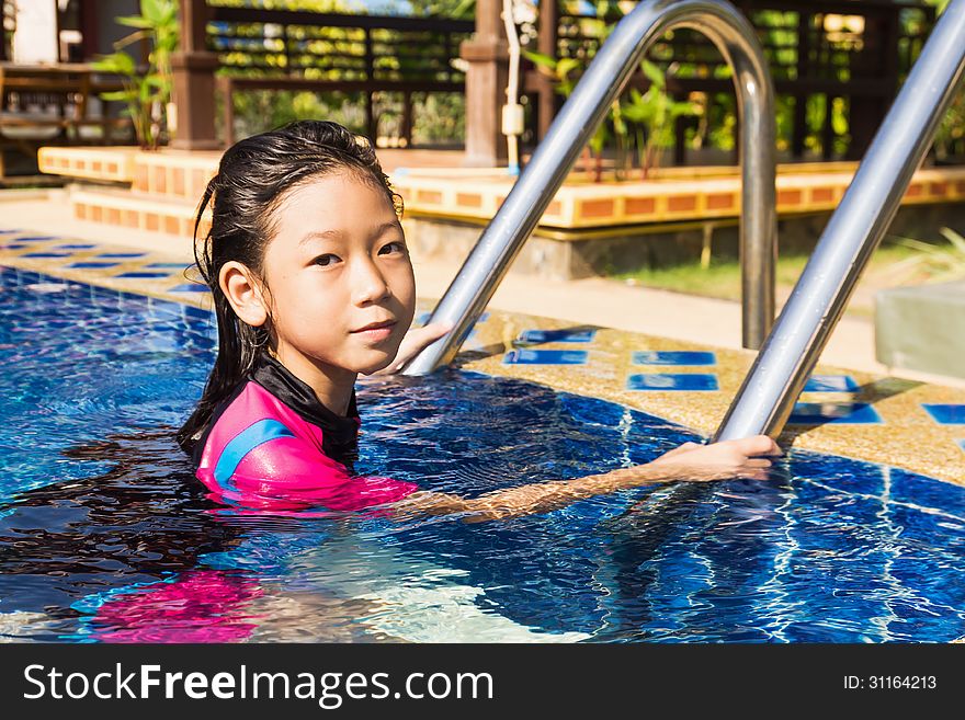 Girl relaxing on the side of a swimming pool. Girl relaxing on the side of a swimming pool