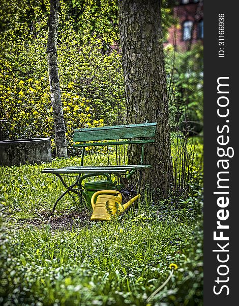 Garden bench with yellow ewer.