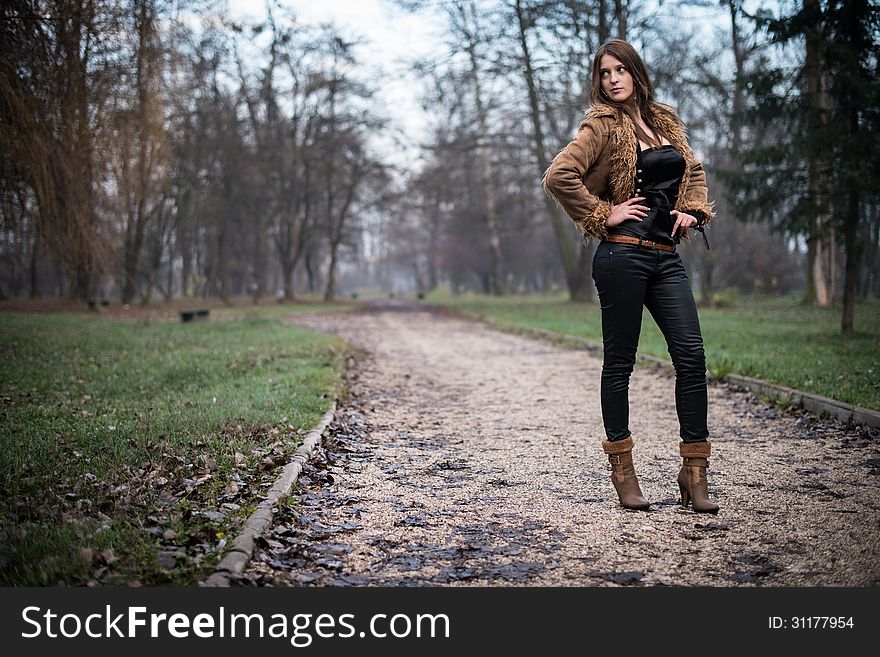 Young Woman In Jacket Standing And Posing