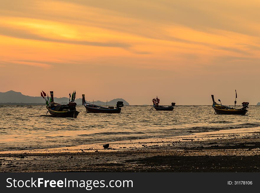 Fishing boats floating on the beach in sunset. Fishing boats floating on the beach in sunset