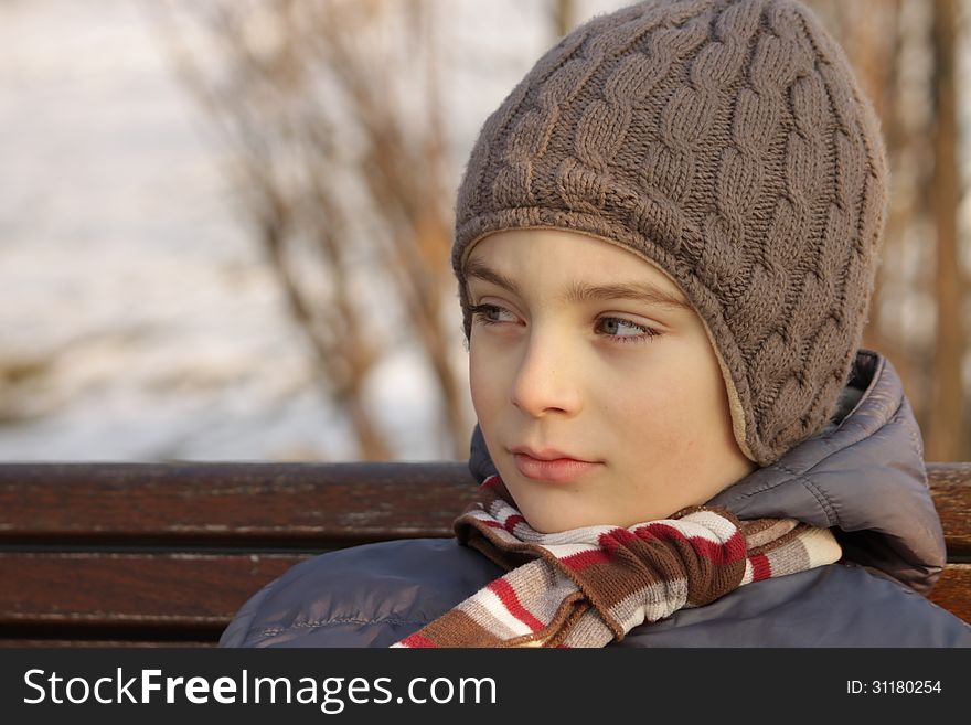 Child sitting on a bench in a park