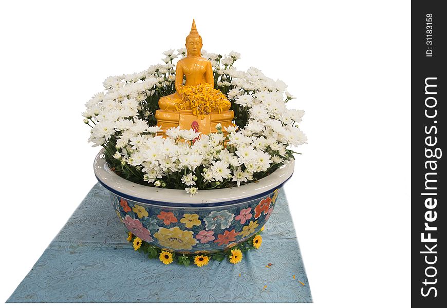 A golden buddha image on a decorated flower vase.