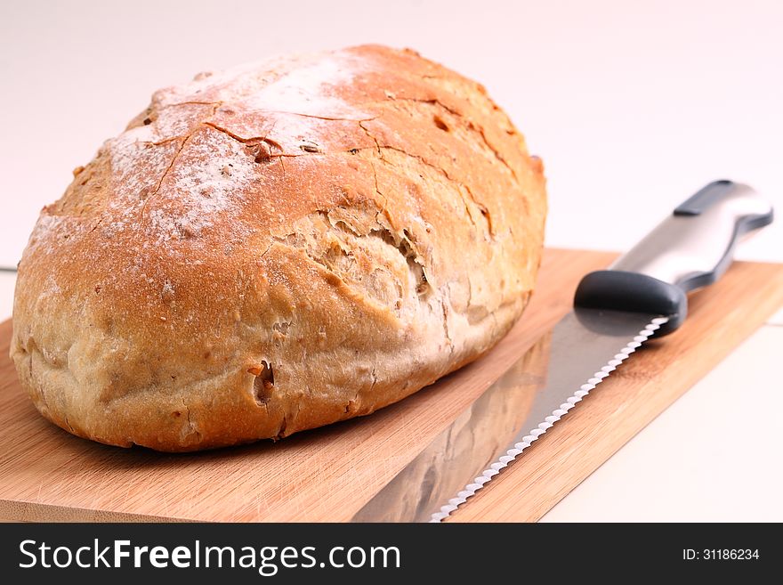 Bread and knife on a cutting board ready for serving. Bread and knife on a cutting board ready for serving.