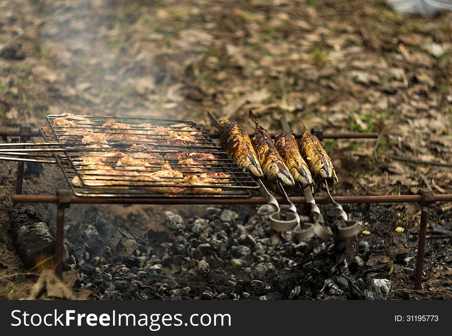 In wood grilled chicken and fried mackerel fish is very tasty and appetizing smells barbeque