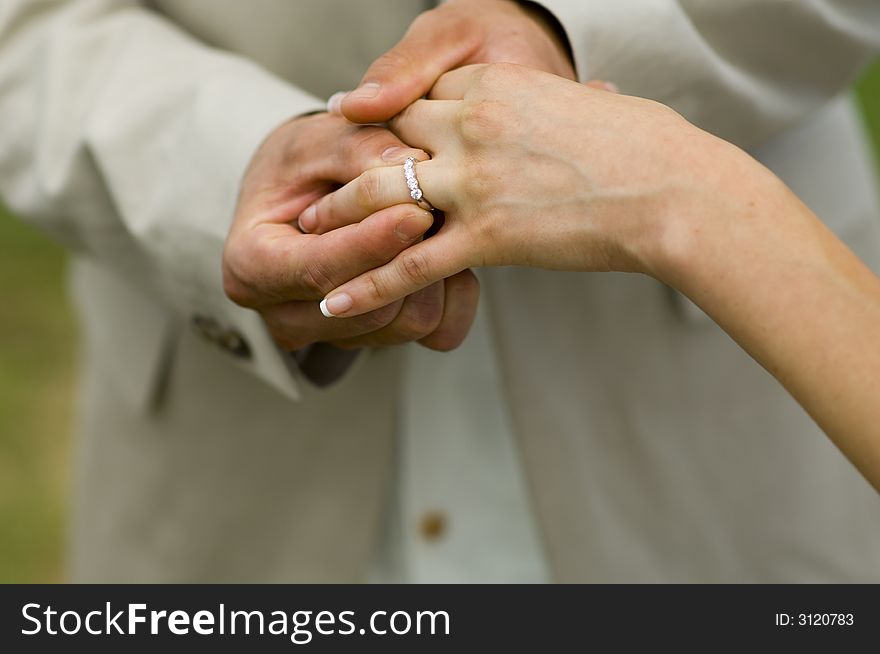 Groom placing wedding band on new bride. Groom placing wedding band on new bride.