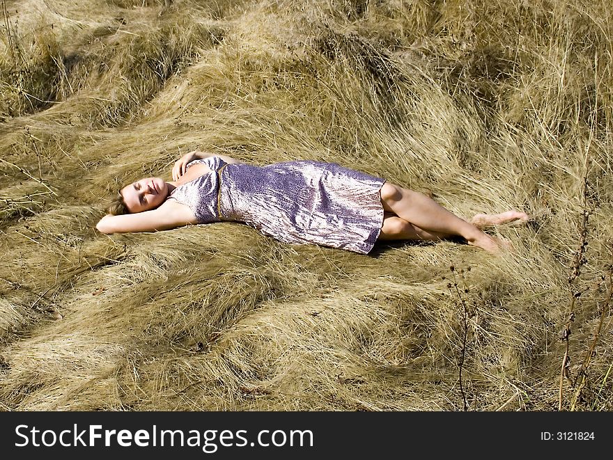 The girl lying on a grass in a hot sunny day. The girl lying on a grass in a hot sunny day