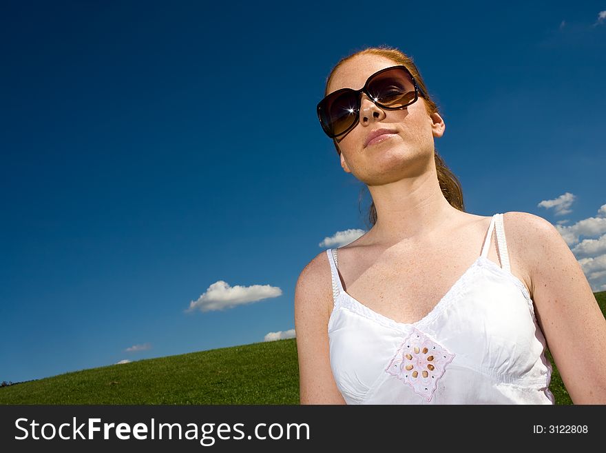 Woman with big sunglasses. Outside with airy clothes. It is great summer. Azure sky, Meadow goes to horizon. Woman with big sunglasses. Outside with airy clothes. It is great summer. Azure sky, Meadow goes to horizon.