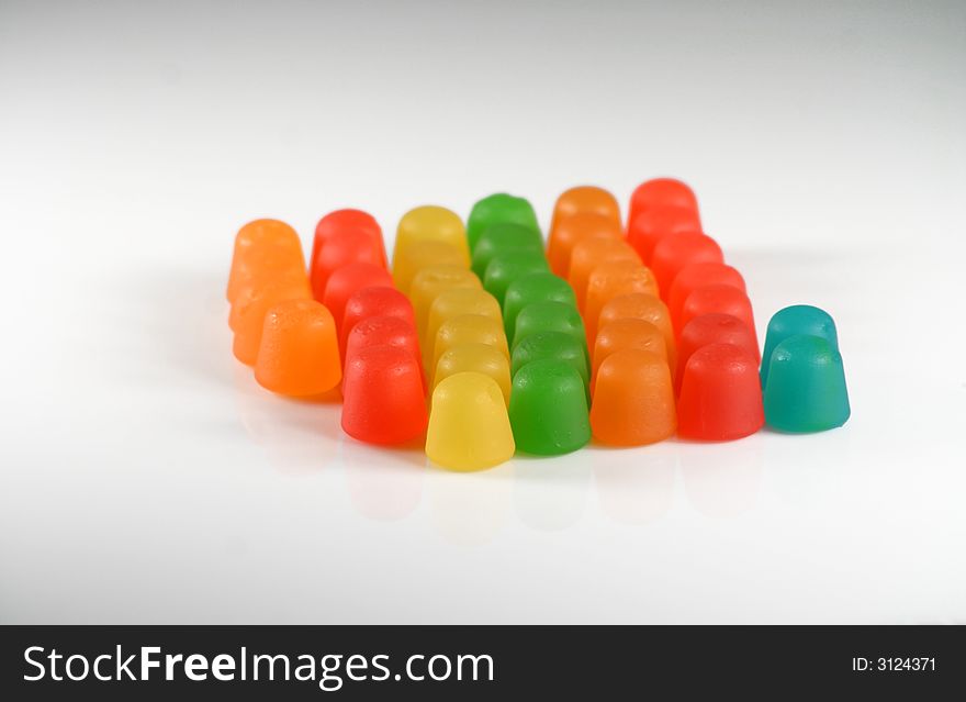 Colorful gummy candy in a line on white