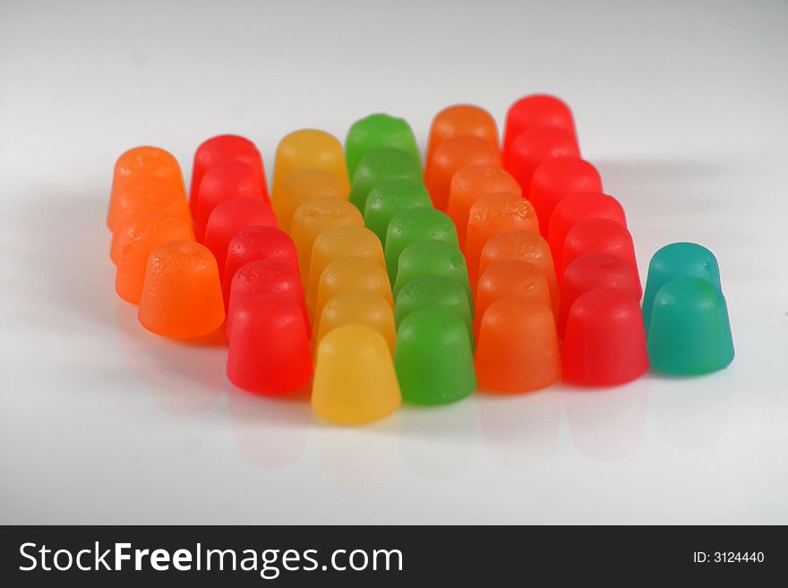 Colorful gummy candy in a line on white