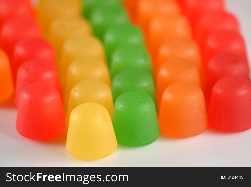 Colorful gummy candy in a line on white