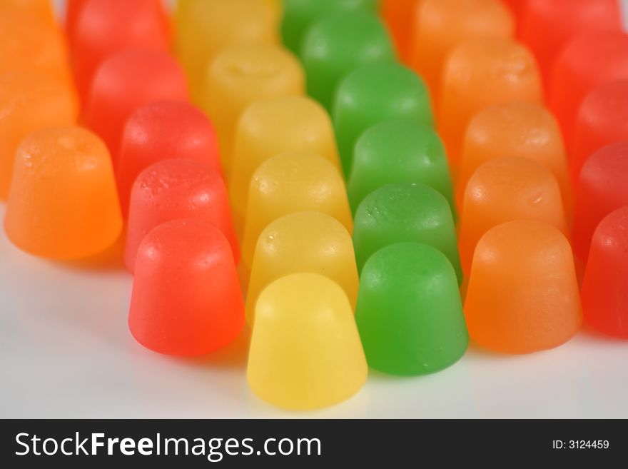 Colorful gummy candy in a line on white. Colorful gummy candy in a line on white