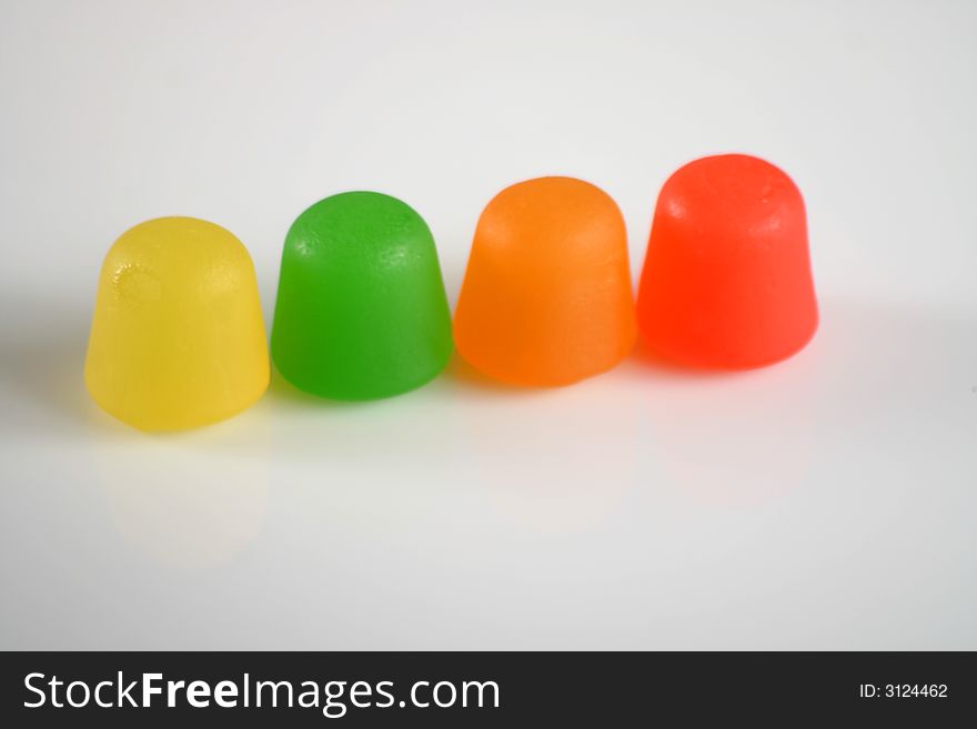 Colorful gummy candy in a line on white