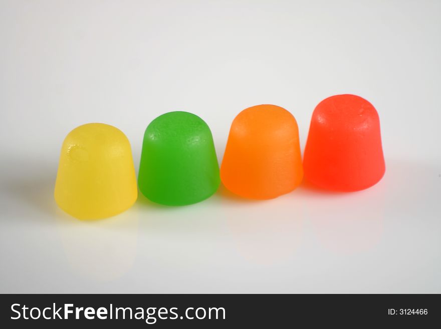 Colorful gummy candy in a line on white