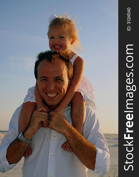 Father holding his daughter on his shoulders at the beach. Father holding his daughter on his shoulders at the beach