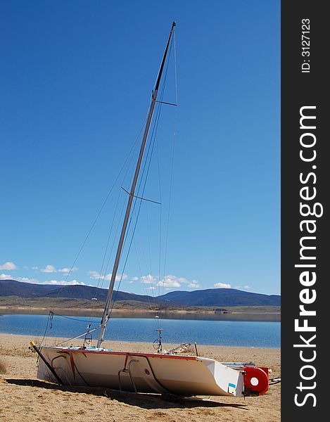 Sailing boat sitting on the sandy beach of a lake shore. Sailing boat sitting on the sandy beach of a lake shore