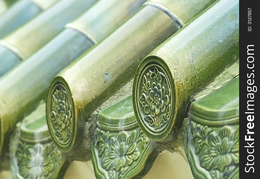 Green, glazed, Chinese roof tiles. Shallow depth of field with the first tile in focus.
