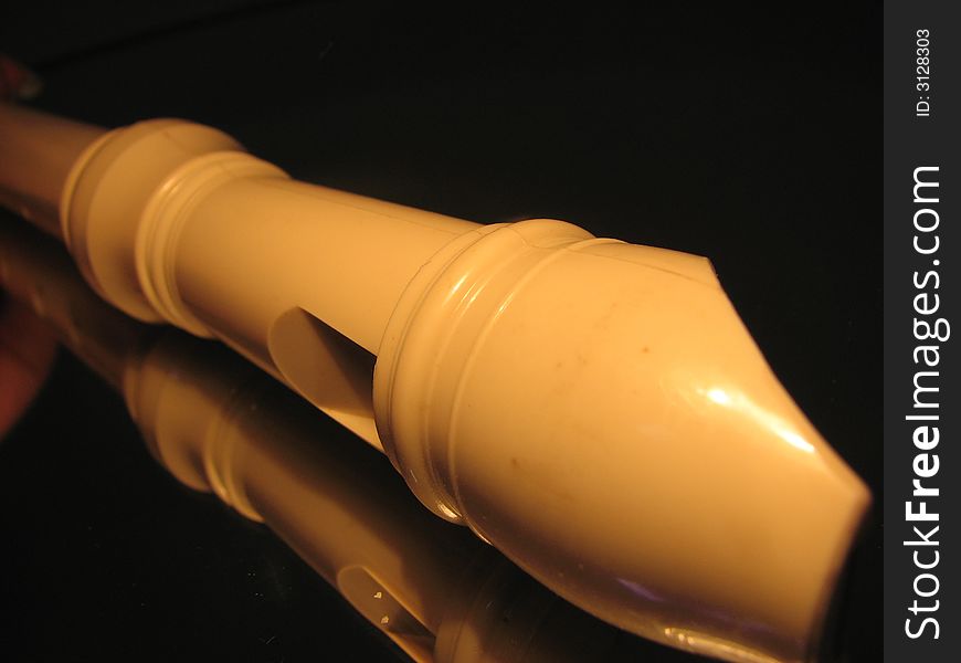 Yellow plastic flute on the dark background. Yellow plastic flute on the dark background.