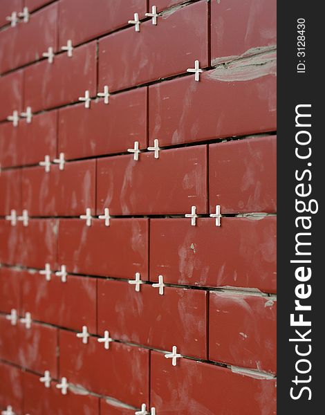 Clinker tiles arranging to wall with pegs.